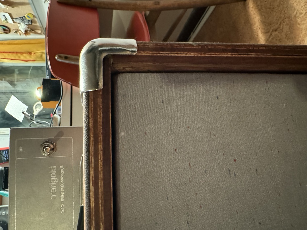 The top corner of the cabinet, showing the mitred wood frame