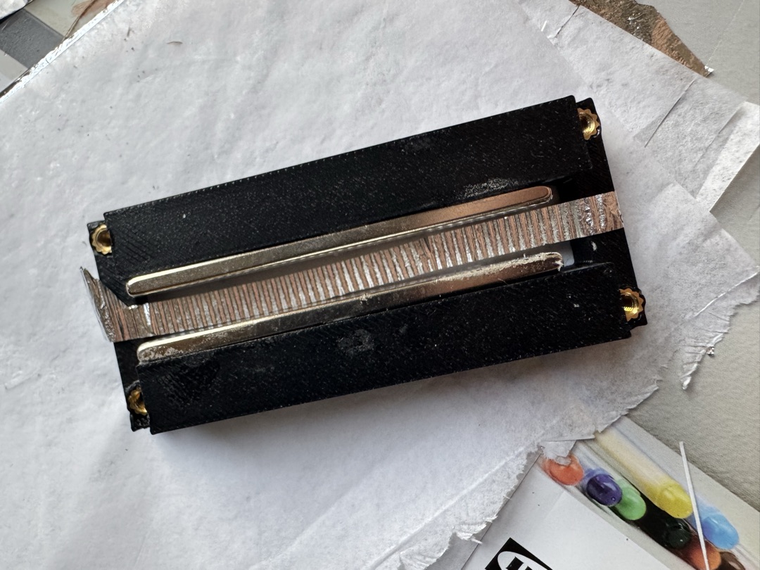 The ribbon motor — a corrugated ribbon suspended between magnets in a black frame