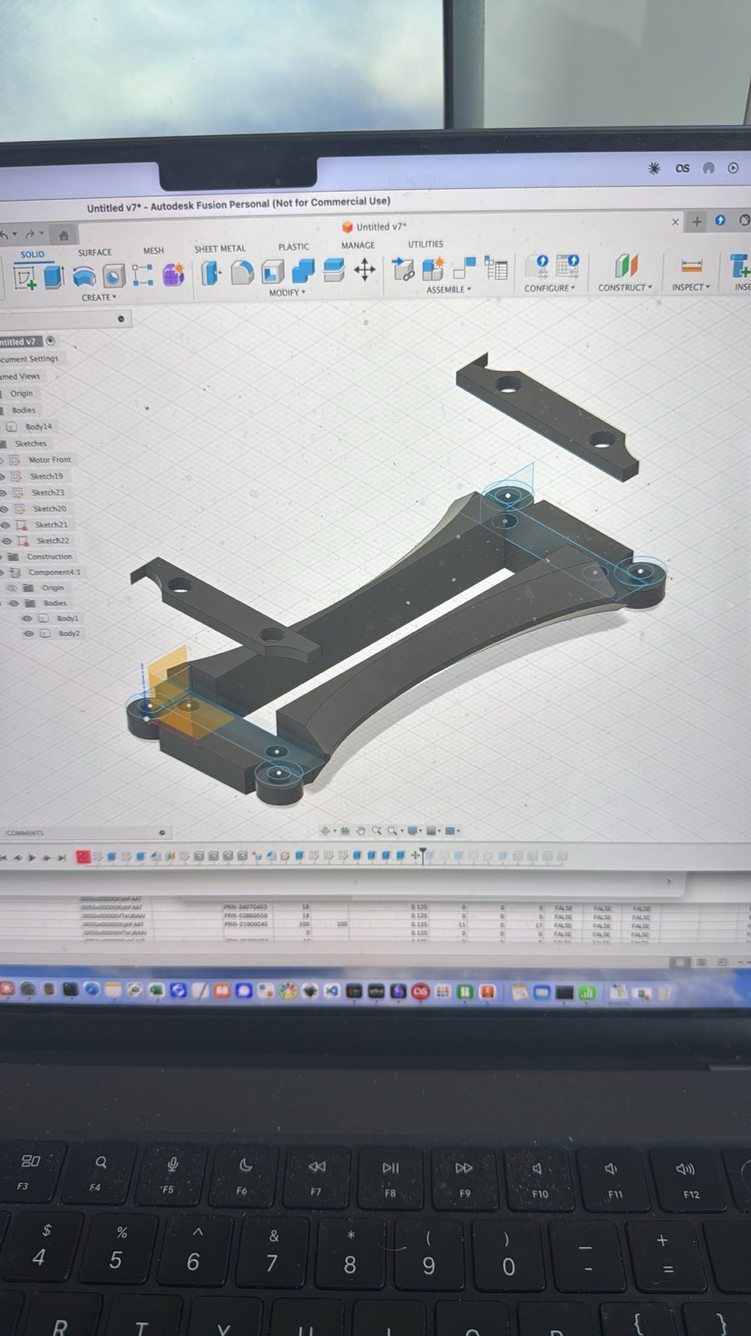 Fusion 360 on the laptop, designing the motor frame
