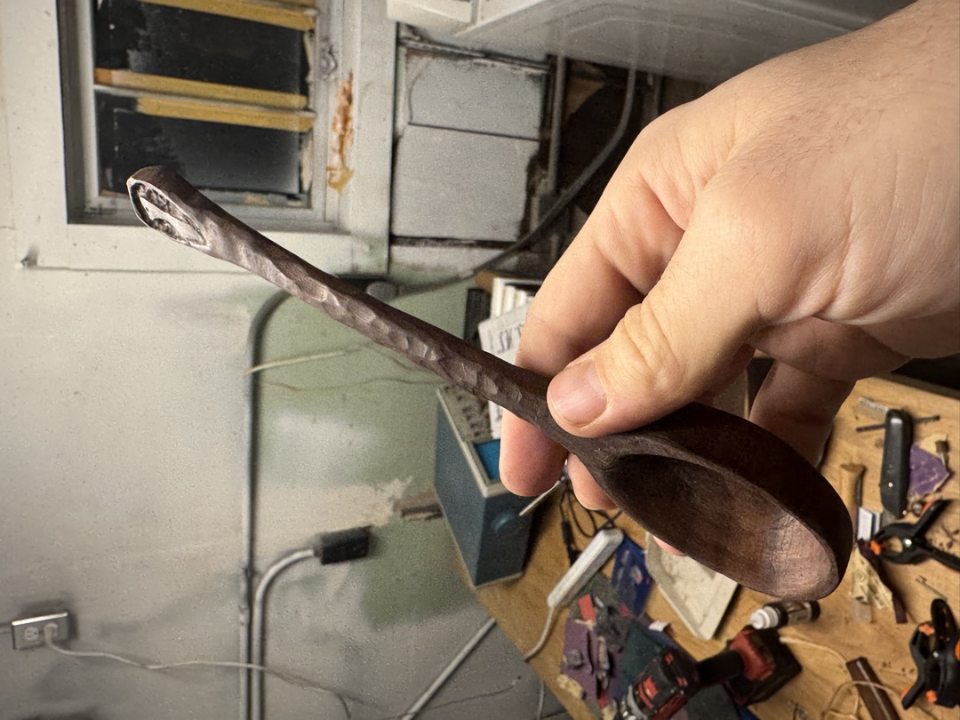 The spoon in hand, its faceted handle catching the light